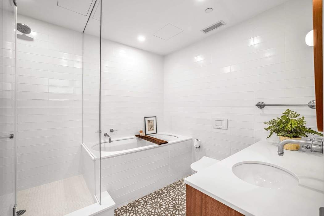 11 West 30th Street, Unit 14 Manhattan, NY 10001 - Photo 13 of 18 a bathroom with a sink a toilet and shower