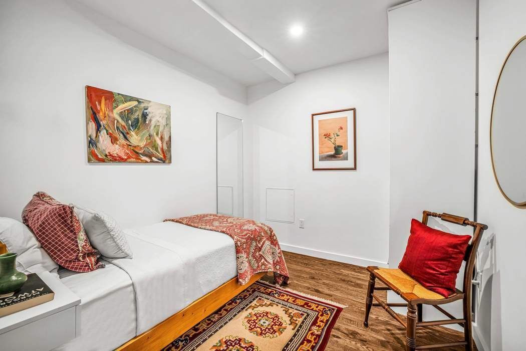 11 West 30th Street, Unit 14 Manhattan, NY 10001 - Photo 14 of 18 a bedroom with a bed and chair