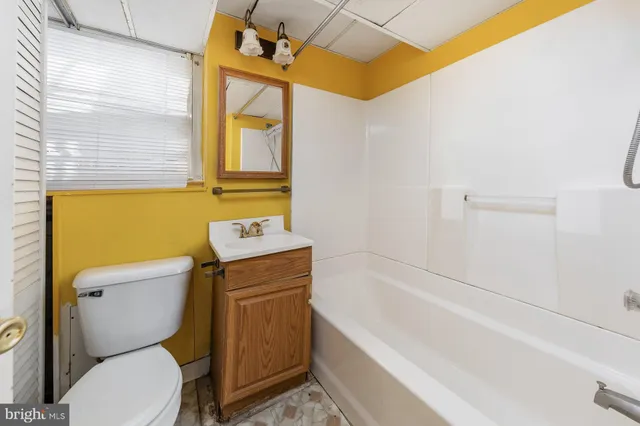 a bathroom with a granite countertop toilet a sink and bathtub