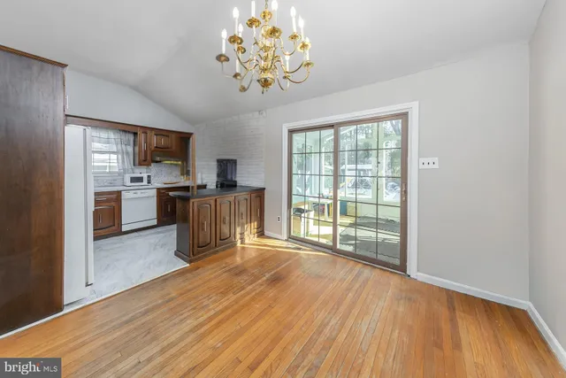 a kitchen with kitchen island wooden floors and stainless steel appliances
