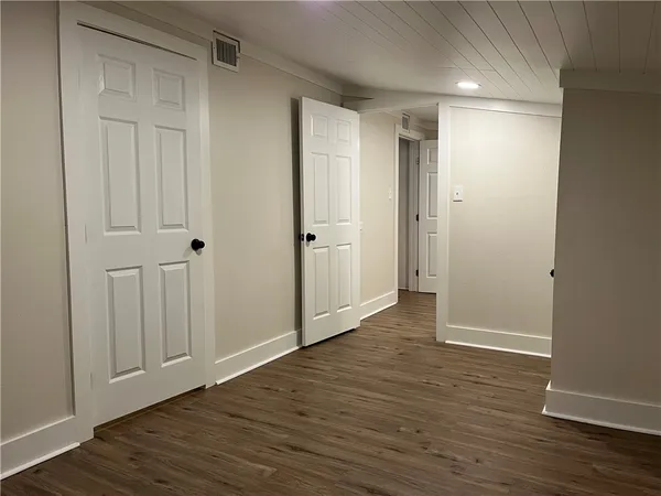a view of empty room with wooden floor