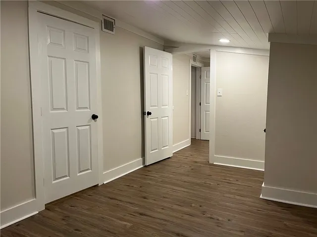 a view of empty room with wooden floor