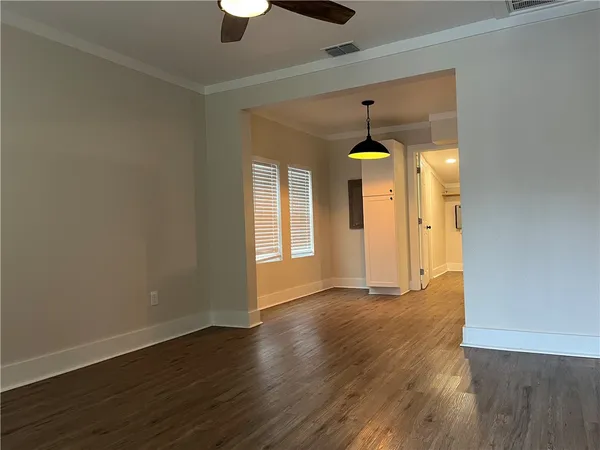 a view of an empty room with window and wooden floor
