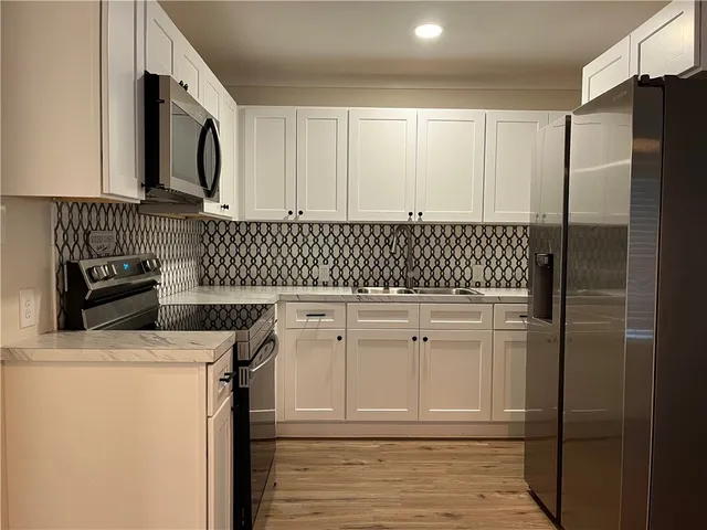 a kitchen with white cabinets and sink