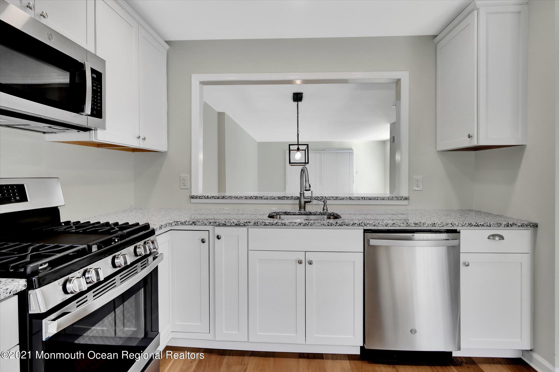 50 Wyckham Road Spring Lake Heights, NJ 07762 - Photo 4 of 27 a kitchen with granite countertop a stove and a microwave
