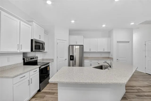 a kitchen with stainless steel appliances granite countertop a refrigerator and a stove