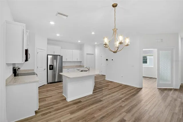 a kitchen with a sink dishwasher and wooden floor