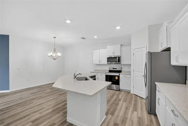 a kitchen with stainless steel appliances granite countertop a refrigerator and a stove top oven