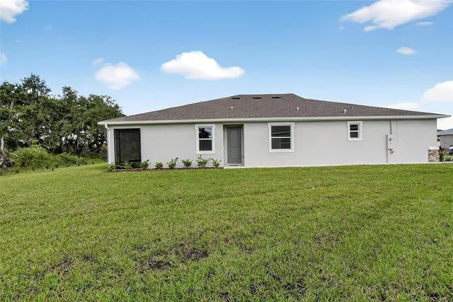 a front view of a house with a big yard and potted plants