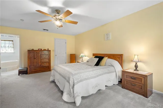 a spacious bedroom with a bed and ceiling fan