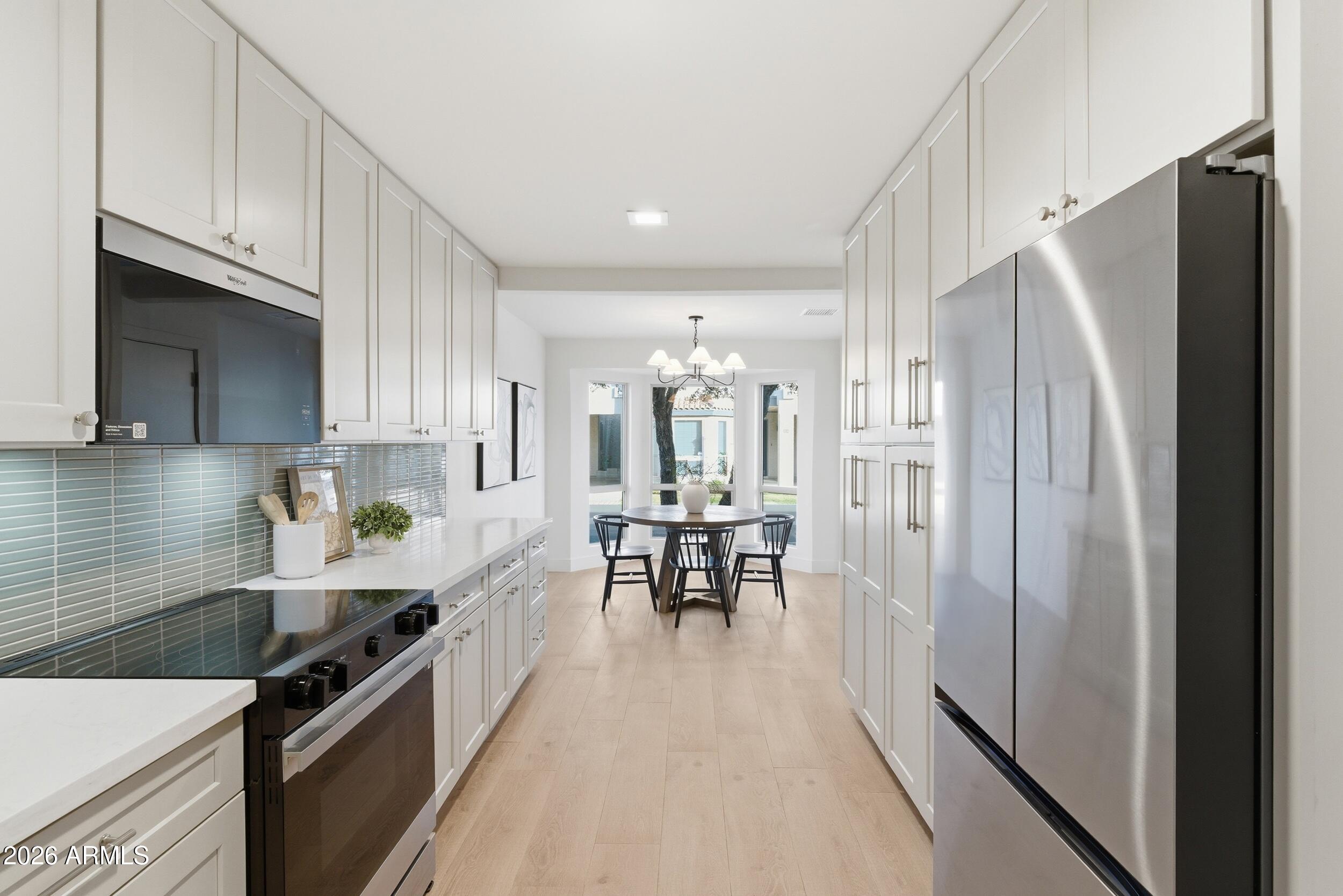 3415 North 36th Street, Unit 3 Phoenix, AZ 85018 - Photo 10 of 33 a kitchen with granite countertop a refrigerator a sink a stove and white cabinets