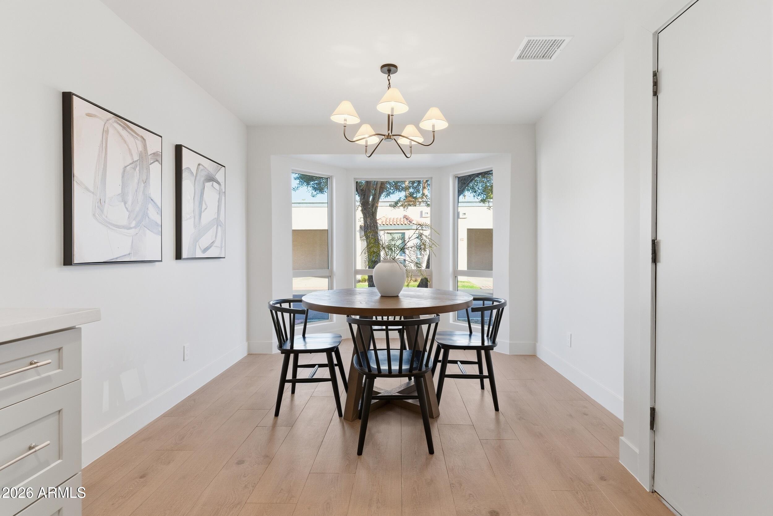 3415 North 36th Street, Unit 3 Phoenix, AZ 85018 - Photo 11 of 33 a view of a dining room with furniture a chandelier and wooden floor