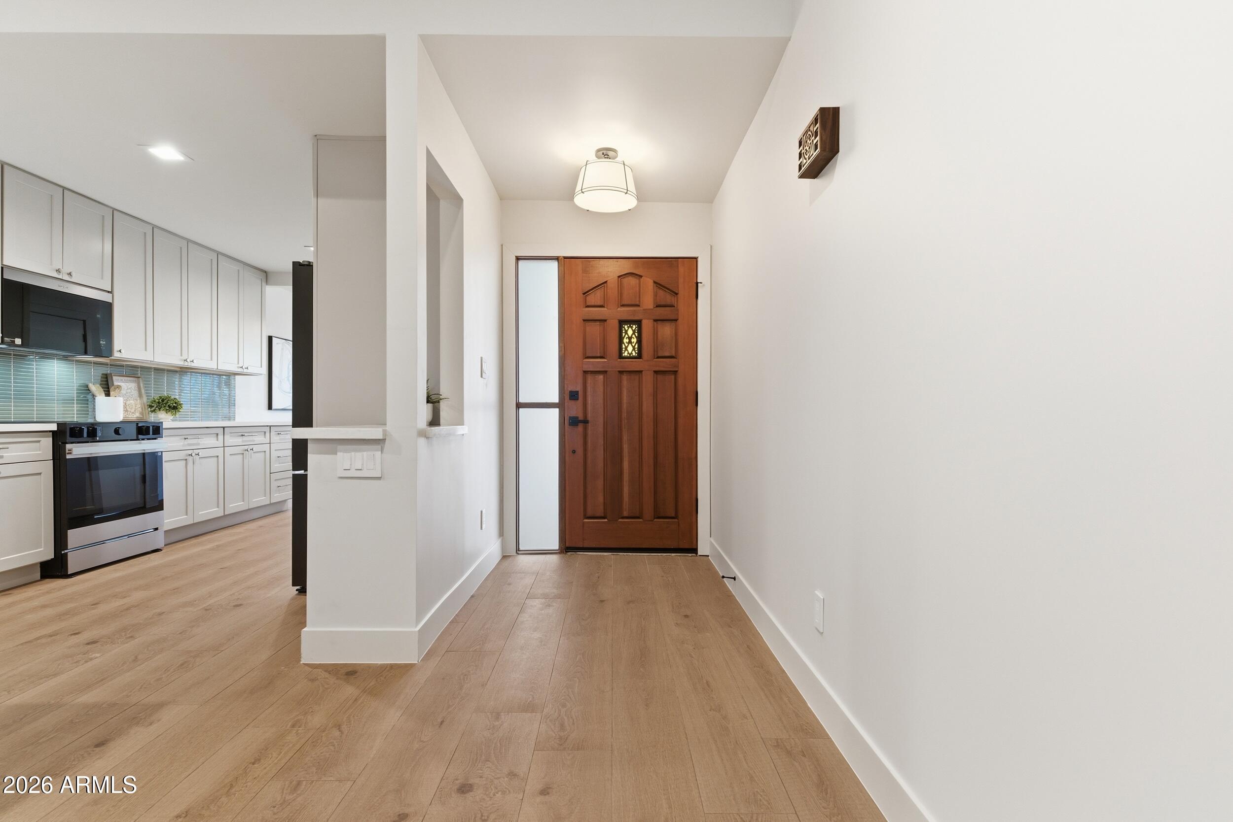 3415 North 36th Street, Unit 3 Phoenix, AZ 85018 - Photo 9 of 33 a view of a hallway with wooden floor and a kitchen