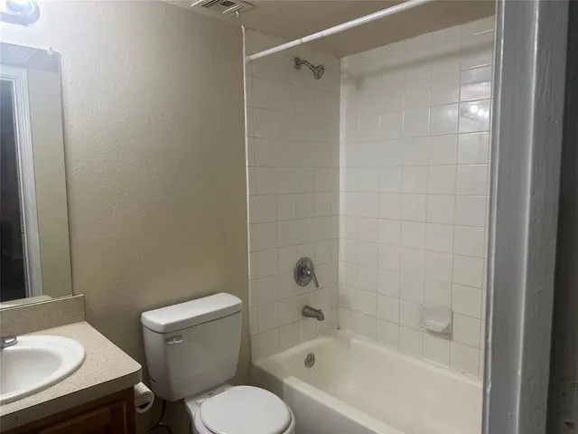 a white toilet sitting next to a bath tub