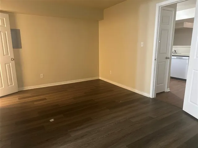 an empty room with wooden floor and a window