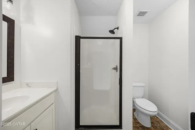 a bathroom with a granite countertop toilet and a sink