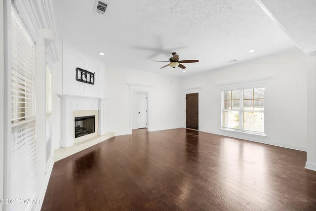 a view of an empty room with a fireplace and a window