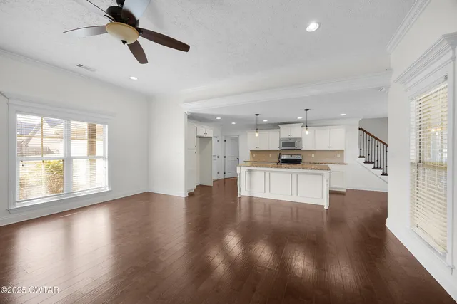 a view of kitchen with granite countertop cabinets and refrigerator
