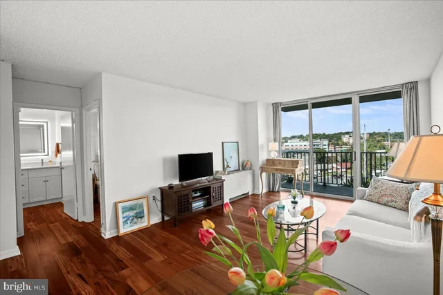 a living room with furniture a flat screen tv and a floor to ceiling window