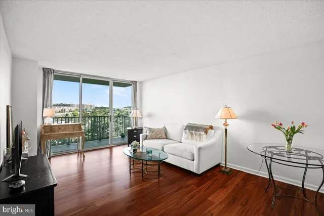 a living room with furniture a table and wooden floor