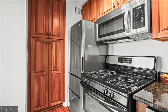 a kitchen with wooden cabinets and a stove top oven