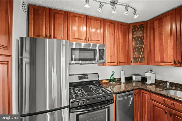a kitchen with stainless steel appliances granite countertop a refrigerator stove and sink