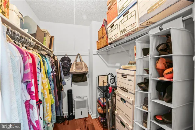 a view of walk in closet with clothes and shoes