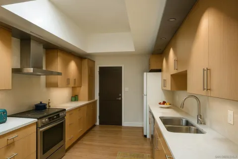 a kitchen that has a sink wooden cabinets and stainless steel appliances