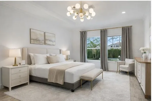 a bedroom with a large bed and a chandelier