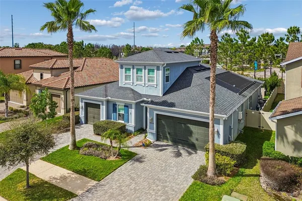 a view of a white house with a yard and potted plants