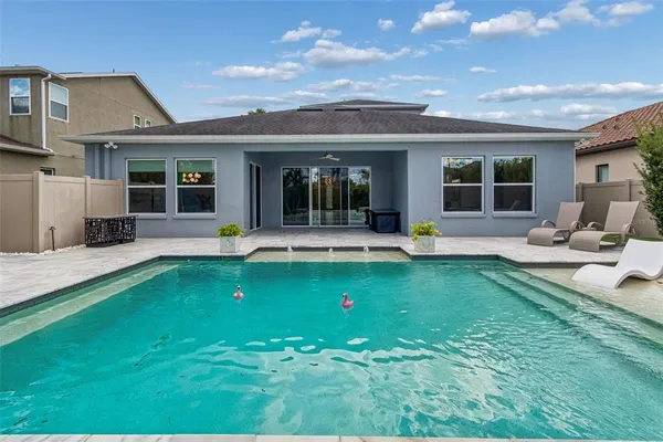 a view of a house with a swimming pool and sitting area