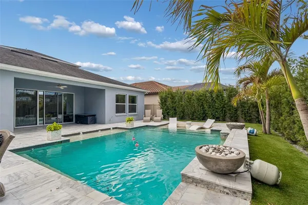 a view of a backyard with swimming pool and furniture