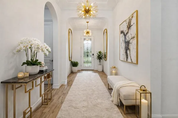 a living room with furniture flowerpot and a chandelier