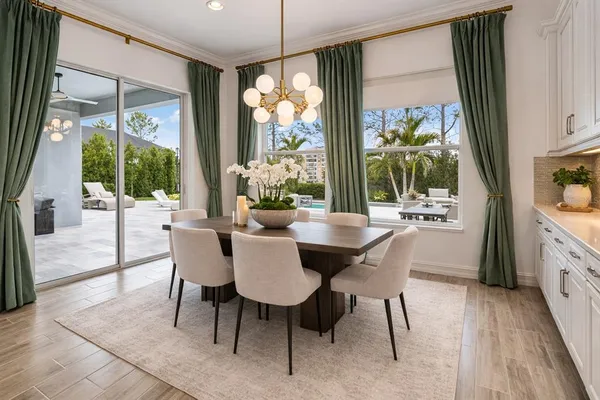 a view of a dining room with furniture large windows and wooden floor