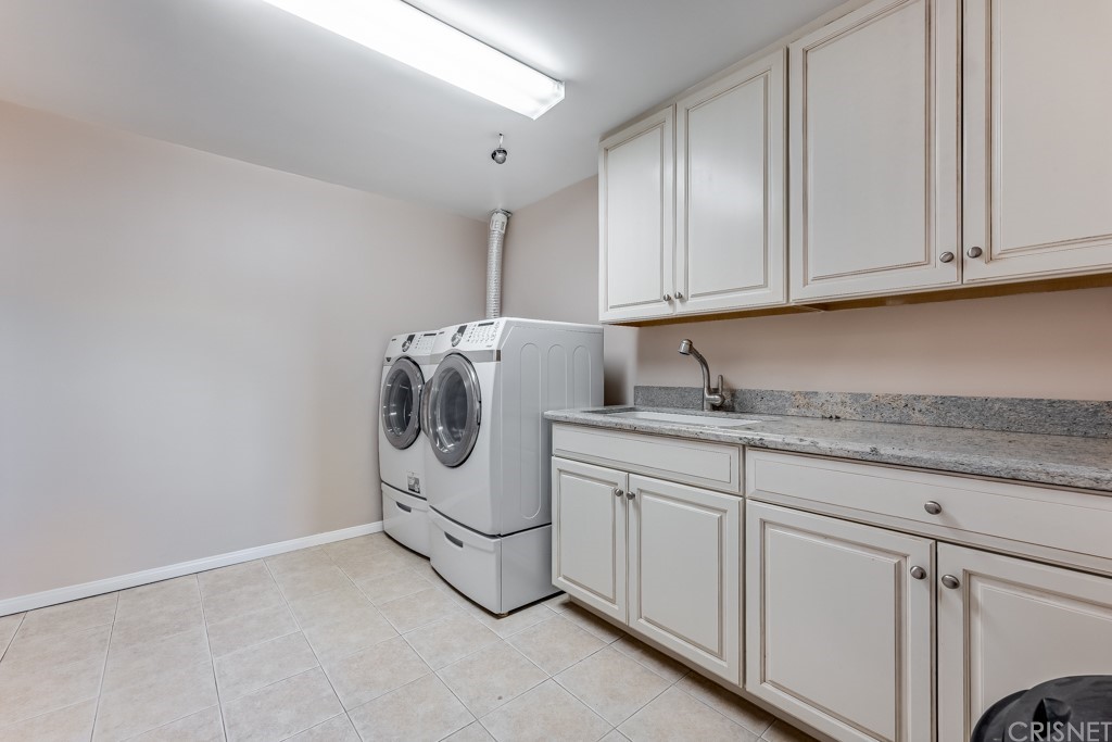150 Saddlebow Road Bell Canyon, CA 91307 - Photo 20 of 37 a utility room with granite countertop cabinets and washer