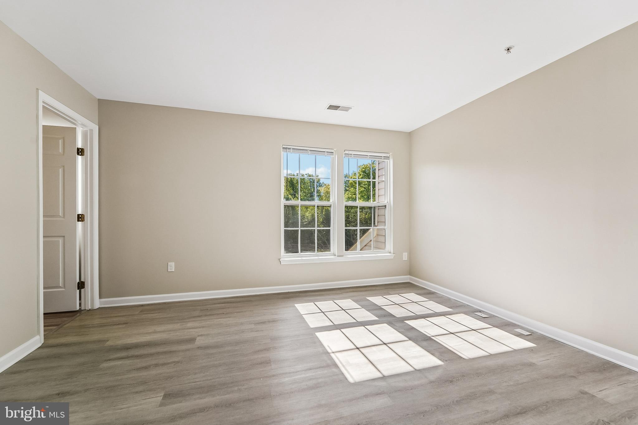 1461 Pangbourne Way Hanover, MD 21076 - Photo 22 of 51 an empty room with wooden floor and windows