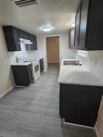 a kitchen with stainless steel appliances a stove a microwave and a sink