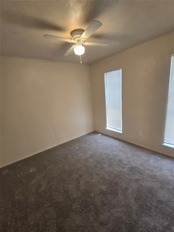 a view of an empty room with a chandelier fan