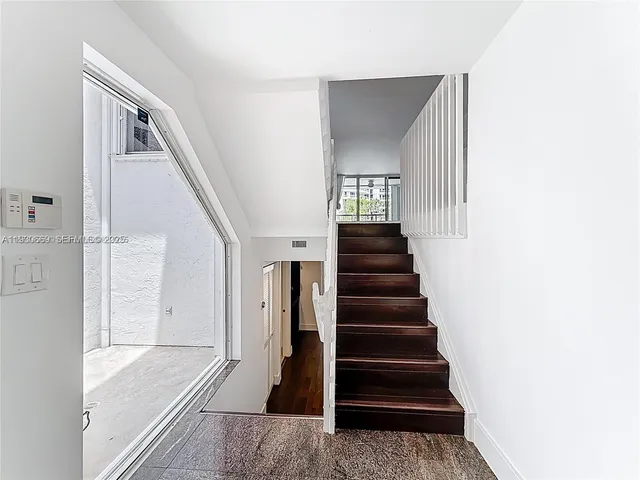 a view of a hallway with wooden floor and entryway
