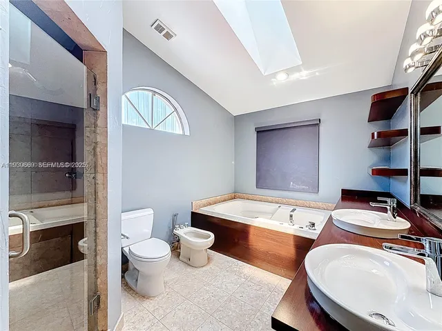 a bathroom with a granite countertop toilet sink and mirror