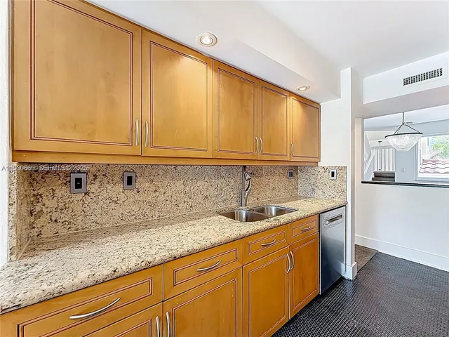 a kitchen with stainless steel appliances granite countertop white cabinets and sink