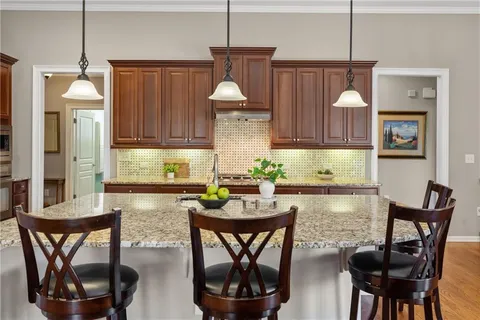 a bathroom with a granite countertop sink a mirror and a shower