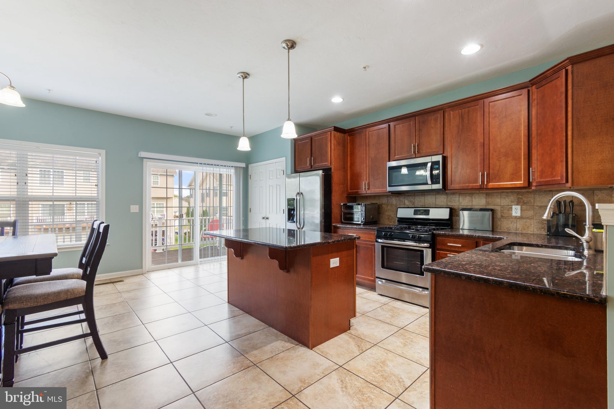 191 Moul Avenue Hanover, PA 17331 - Photo 15 of 49 a large kitchen with stainless steel appliances granite countertop a stove a sink a microwave and a dining table