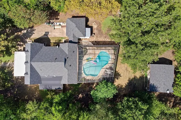 an aerial view of a house with outdoor space and a garden