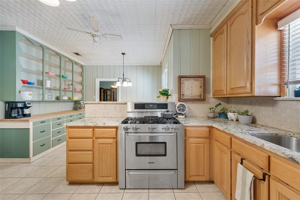 233 East High Street Wills Point, TX 75169 - Photo 12 of 40 Kitchen featuring stainless steel gas stove, tasteful backsplash, a peninsula, light stone counters, and ceiling fan