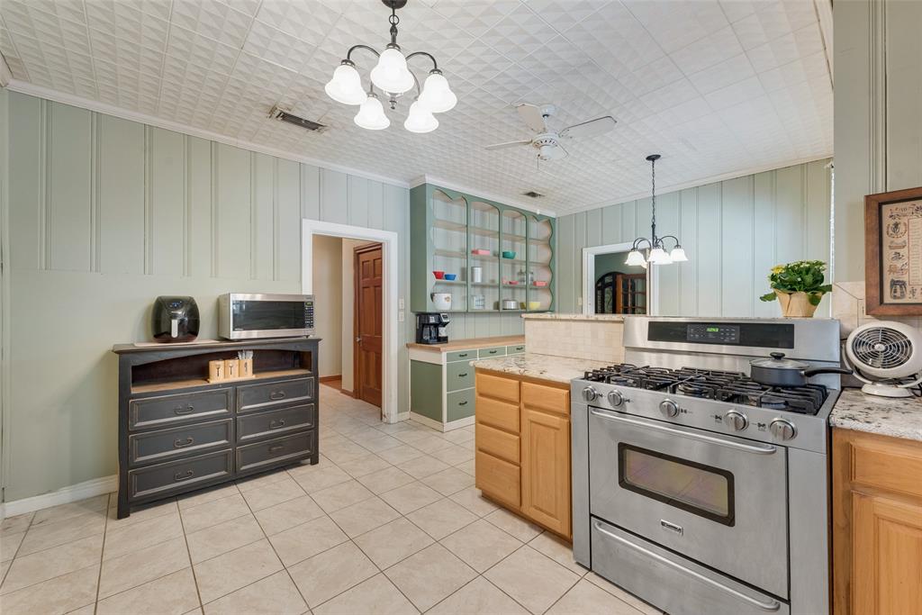 233 East High Street Wills Point, TX 75169 - Photo 13 of 40 Kitchen with a chandelier, stainless steel appliances, ceiling fan, light tile patterned floors, and crown molding