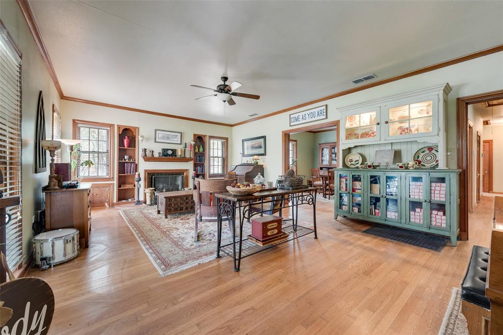 233 East High Street Wills Point, TX 75169 - Photo 5 of 40 Living room with light wood finished floors, a ceiling fan, crown molding, and a fireplace