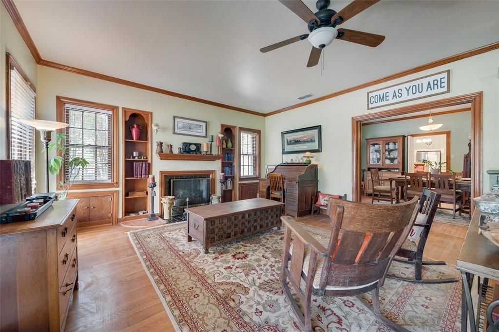 233 East High Street Wills Point, TX 75169 - Photo 6 of 40 Living room featuring light wood-type flooring, ornamental molding, a fireplace with flush hearth, and a ceiling fan