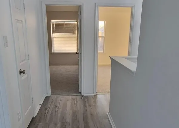 a view of an empty room with closet and a window