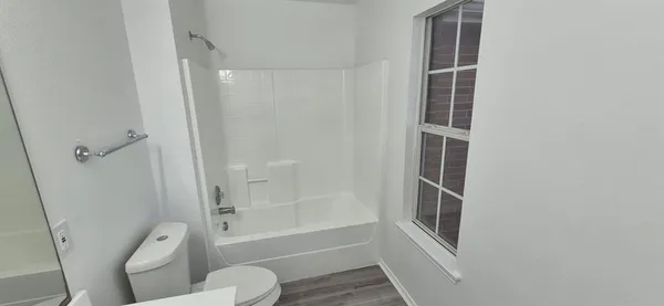 a bathroom with toilet shower and tub